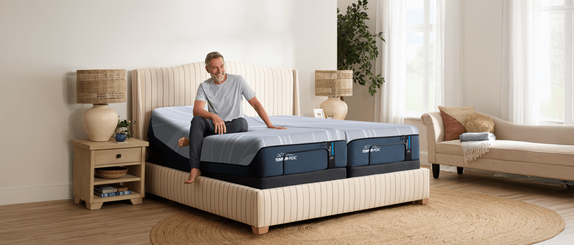 a man sitting crossed legged on the luxe align with the head of one mattress lifted to show a split king power base