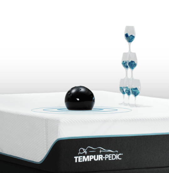 bowling ball and stack of wine glasses on a mattress to show motion cancellation