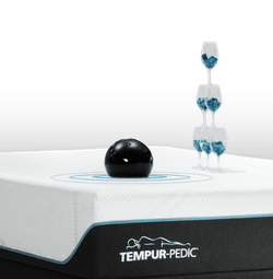 bowling ball and stack of wine glasses on a mattress to show motion cancellation