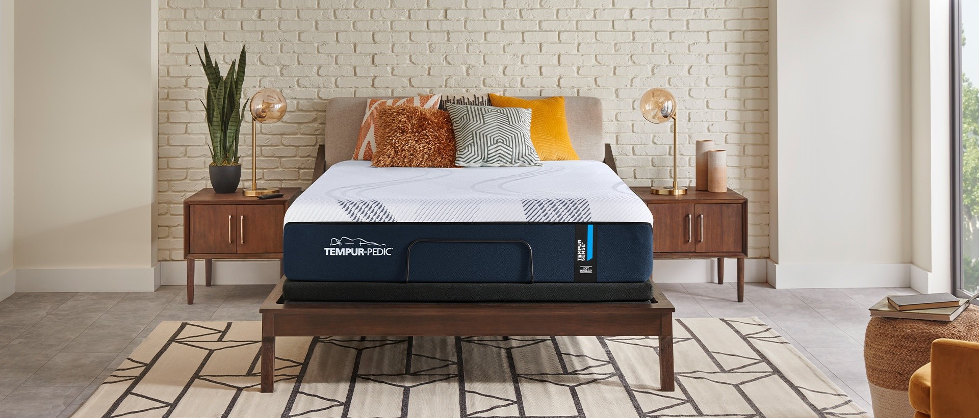 A Tempur Sense mattress in a pleasant styled white room sitting on a wood bedframe