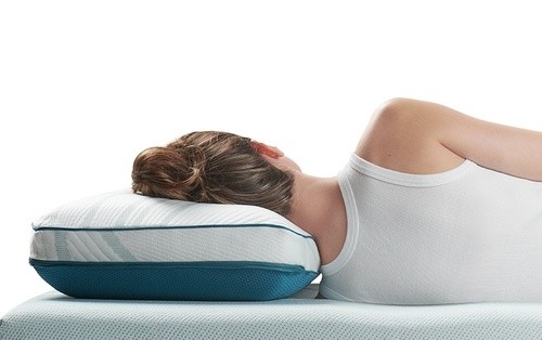 a woman resting her head on the Adapt back and side pillow